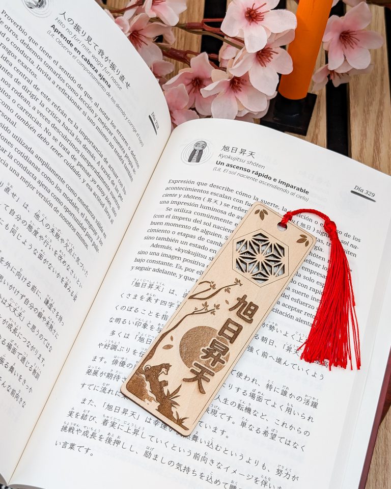 Libro abierto con un punto de libro de madera y flores de cerezo